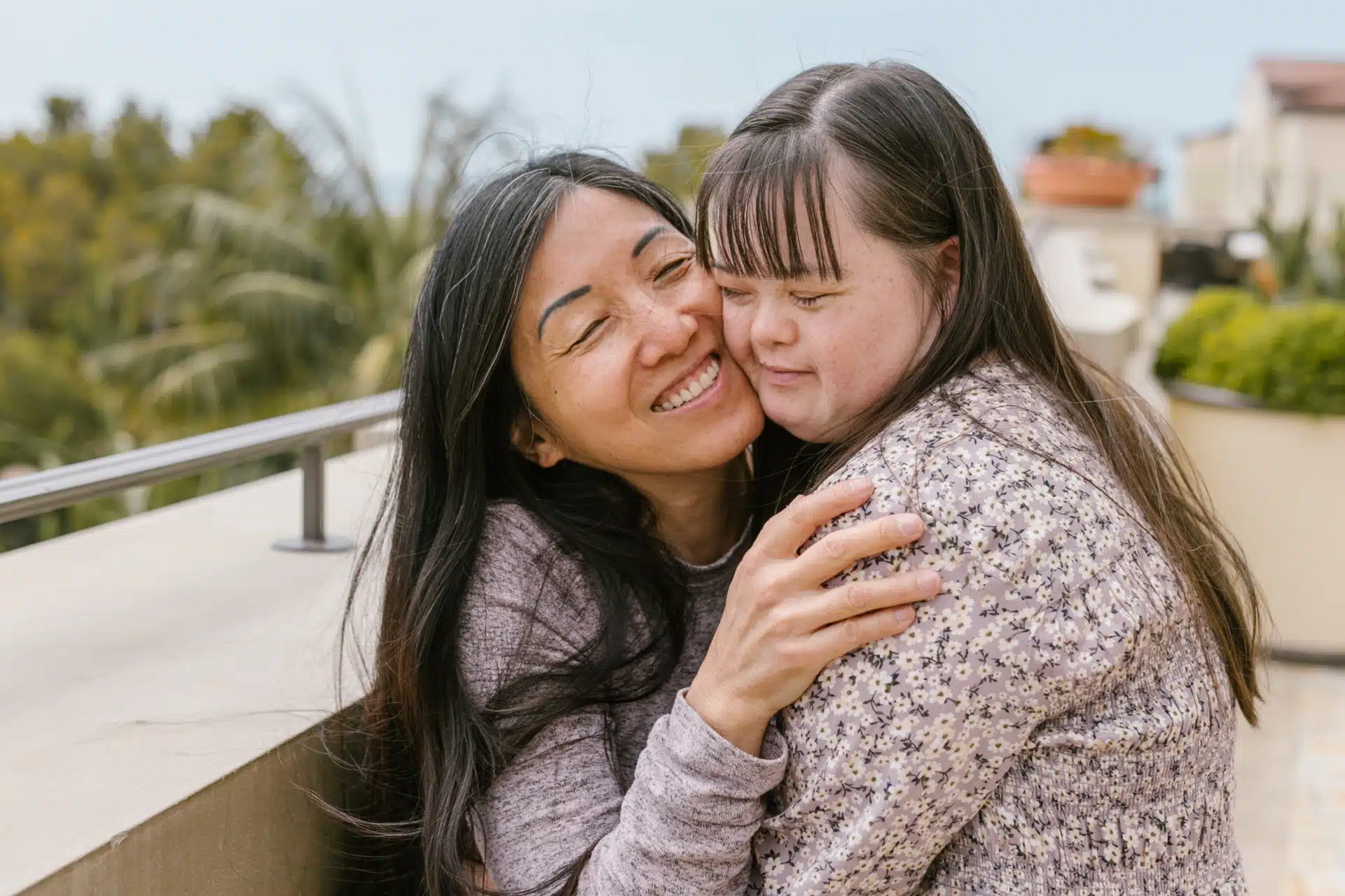girl with downs syndrome hugs woman 3x2.
