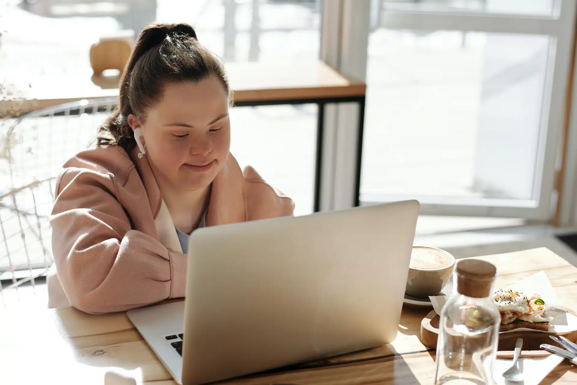 downs syndrome girl in pink studying at laptop 3x2.