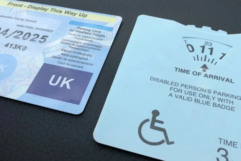 A UK disabled parking permit and its accompanying time-of-arrival clock disc.