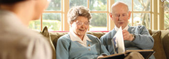 An elderly couple looking through a photo album