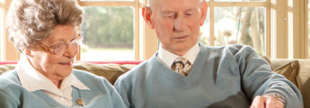 An elderly couple looking through a photo album