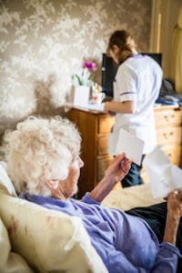 A carer checking medication procedures for a customer
